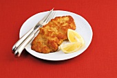 Grilled wiener schnitzel with lemon on plate