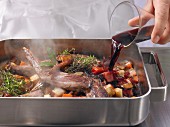 Roasted wild hare being basted with red wine