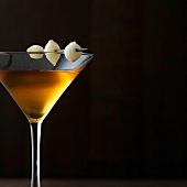 Martini golden gibson with three pearl onions on rim in martini glass