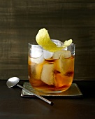 Old fashioned classic whiskey with lemon peel and ice in glass