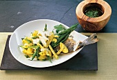 Pasta with pesto, potatoes and sea bream on plate
