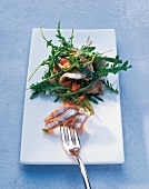 Marinated anchovies with arugula salad on plate