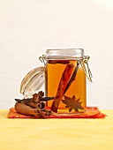 Rum spice, cinnamon sticks and anise in glass jar with preserving liquid
