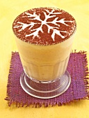 Coffee milk decorated with cocoa powder in glass