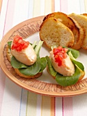 Salmon mousse crostini with lettuce on plate