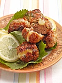 Mince and cheese balls with lemon on lettuce leaves