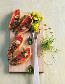 Red mullet with potato salad pesto on wooden board