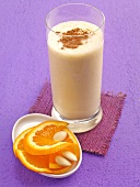 Almond and orange shake with cinnamon powder in glass