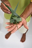 Man holding bird made from palm leaves, Dhigufinolhu island, Maldives