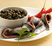 Capers, anchovies and red chillies on plate