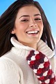 Portrait of pretty woman wearing white sweater with woollen gloves, smiling