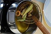 Vegetables being fry in oil while preparing squid tempura, step 3