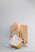 Slices of white bread on wooden cutting board and in freezer bag