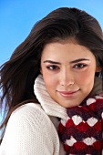 Portrait of pretty woman wearing white sweater with woollen gloves, smiling