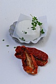 Dried tomatoes and goat cheese on white background