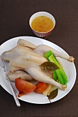 Raw chicken and vegetables on plate while preparing chicken broth