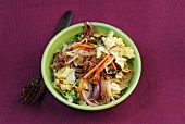 Bami goreng with noodles, ear mushrooms and beef in bowl