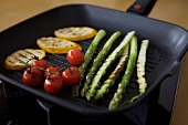 Green asparagus, cherry tomatoes and zucchini in pan