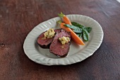 Plate with steak, butter and carrot