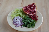 Sliced cucumber, pomegranate and onion on plate