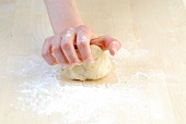 Dough being knead in flour while preparing samosas, step 1