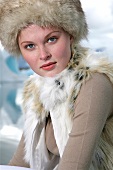 Portrait of pretty gray eyed woman wearing fur hat and fur vest
