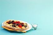 Berry pizza with nuts on blue background