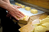 Person pressing cream and whey fat into wooden molds