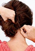 Frau steckt sich die Haare hoch, Step 3 zu Hochsteckfrisur
