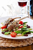 Mixed bean vegetable salad with gratin of lamb chops on plate