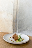 Fried veal breast fibres with veal tongue, celery and sauce on plate