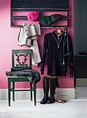 Chair below coat rack mounted on lilac wall