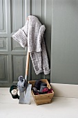 Knitted sweater on spade with wools in wooden basket