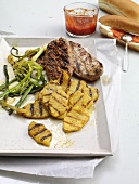 Grilled meat, pineapple slices and leeks in serving dish