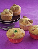 Muffins with amarettini and fruits on purple background