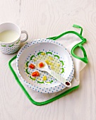 Children's plate, cup, spoon and apron on table made of plastic