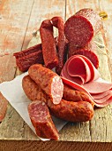 Various types of ham and salami on a wooden board