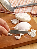 Edges being cut of egg yolk with knife on cutting board, step 2