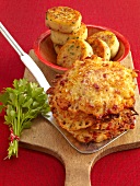 Potato pancakes with bacon and potato cakes on wooden chopping board