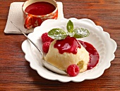 Semolina pudding with raspberries and raspberry sauce in serving dish