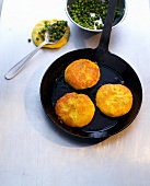 Three potato and pea cookies in pan and boiled peas in bowl and spoon, Indian fast food