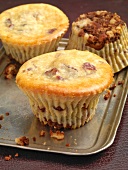 Close-up of three cheesecake muffins with cranberries and chocolate on silver tray
