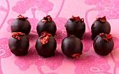 Strawberry balsamic chocolates with dried strawberries on pink background