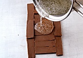 Close-up of sugar syrup being poured on chocolate nougat slices, step 2