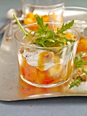 Peaches and chai with goat cheese, arugula and cashew nuts in glass bowl
