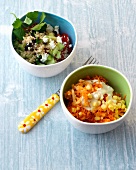 Bowls of couscous salad with feta cheese and carrots with corn rohkost