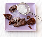 Chocolate banana schmarrn with sieve filled with icing sugar on plate