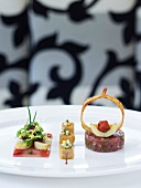 Carpaccio of tuna tartare, artichokes, veal sweetbreads croutons and sauce on plate