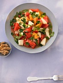 Watermelon salad with chili, ginger dresden sing and sesame crackers in serving dish