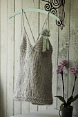 Knitted top with spaghetti straps and a flower bow on hanger